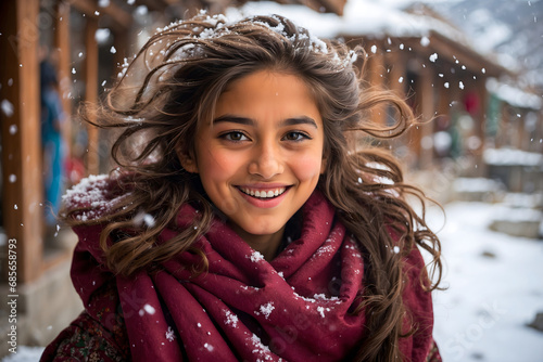 A cute hunza valley girl blushing and spreading happiness in dancing snowflakes, winter concept    photo