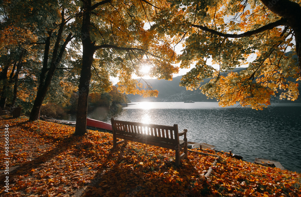 Beautiful fall scenery in Zell am See, Austria with bench, golden foliage and ship on a lake, Salzburg Land, Austria
