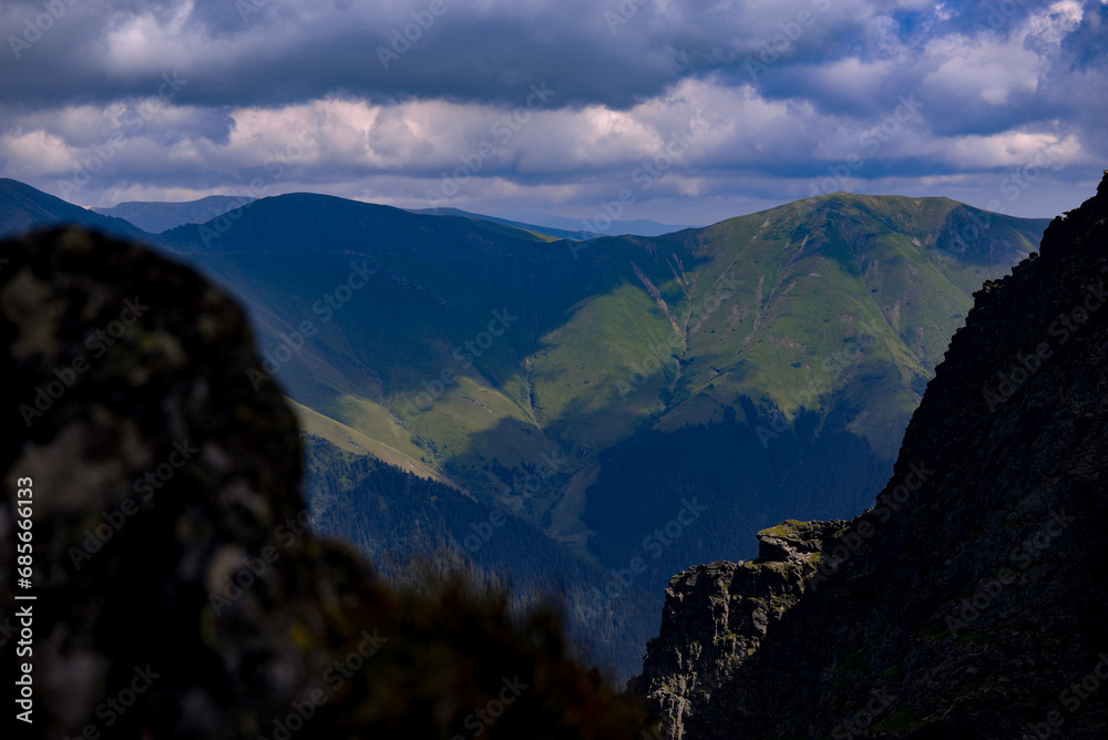 Amazing landscape in Fagaras mountains with spectacular white clouds and blue sky in Romania