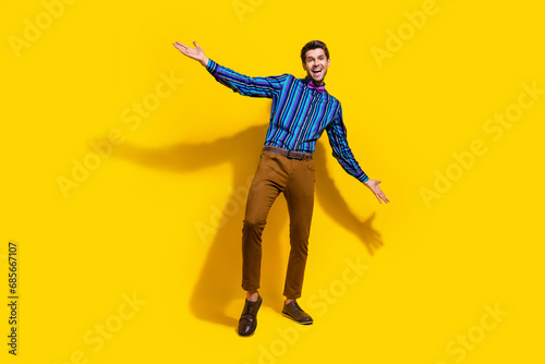 Full size photo of good mood funky guy dressed striped shirt brown trousers announcing black friday isolated on yellow color background