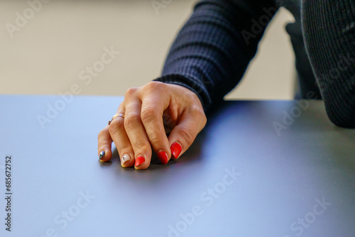 A manicured hand on a table top.