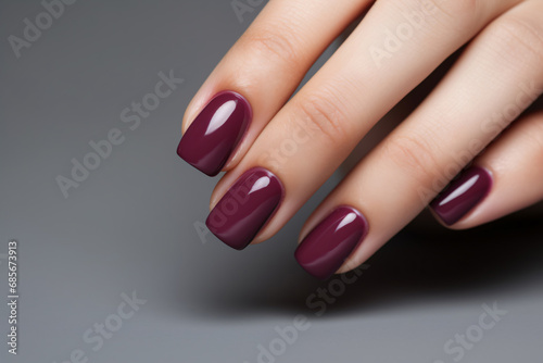 Glamour woman hand with deep berry and plum nail polish on fingernails. Nail manicure with gel polish at luxury beauty salon. Nail art and design. Female hand model. French manicure.