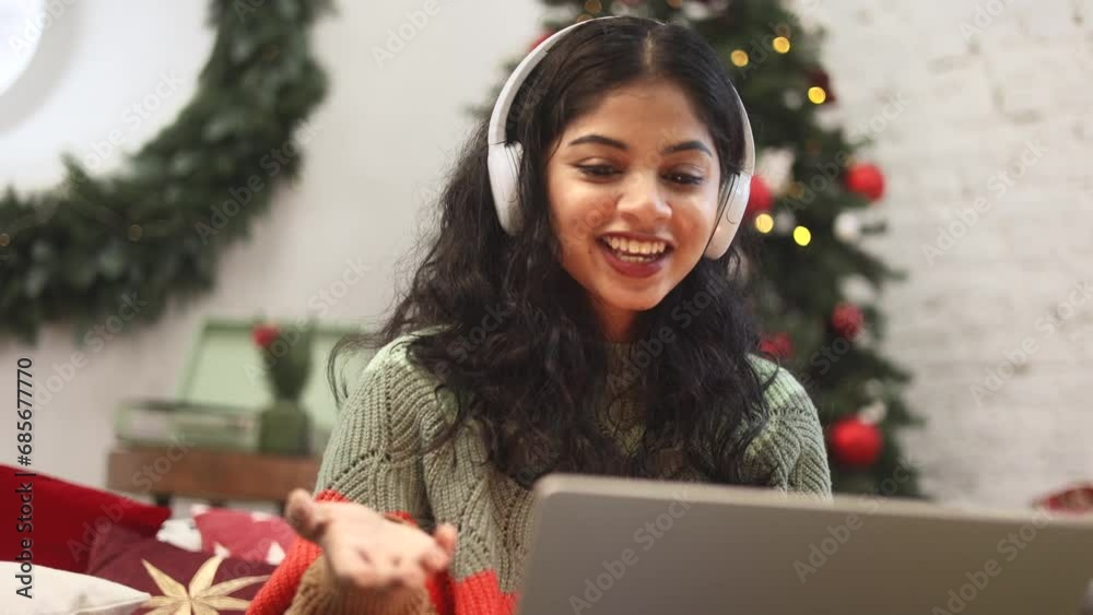 Beautiful young woman have video call conference meeting conversation on laptop sitting on bed near Christmas tree with decoration at cozy home Happy smiling lady talking by computer indoors Beautiful young woman have video call conference meeting conversation on laptop sitting on bed near Christmas tree with decoration at cozy home Happy smiling lady talking by computer indoors