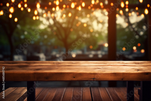 An empty wooden table with a soft focus on blurred bokeh lights hanging from the trees in the background. Cozy evening at cafe concept © Cherstva