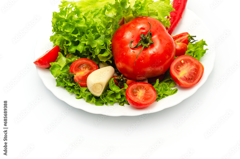Delicious vegetable salad in a bowl on a white background. Chopped tomatoes, lettuce, garlic.