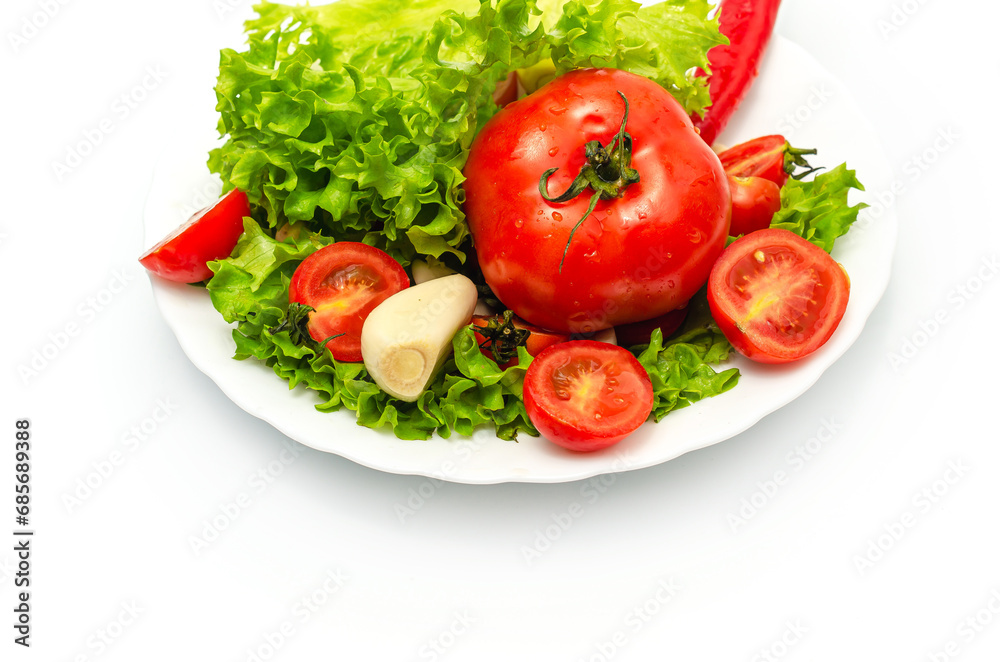 Delicious vegetable salad in a bowl on a white background. Chopped tomatoes, lettuce, garlic. Delicious vegetable salad in a bowl on a white background. Chopped tomatoes, lettuce, garlic.