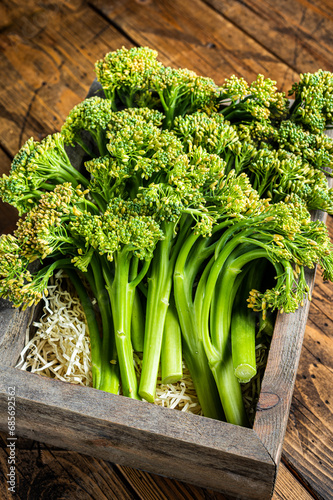 Raw Organic Fresh Broccolini Vegetable in a wooden box. Wooden background. Top view