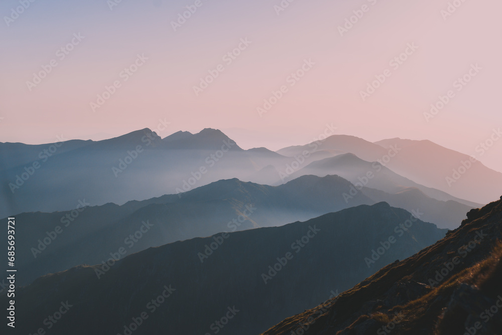 Sharp mountain peaks seen in stunning light from high altitude. Fairy tale landscape with wild Carpathians - obrazy, fototapety, plakaty 