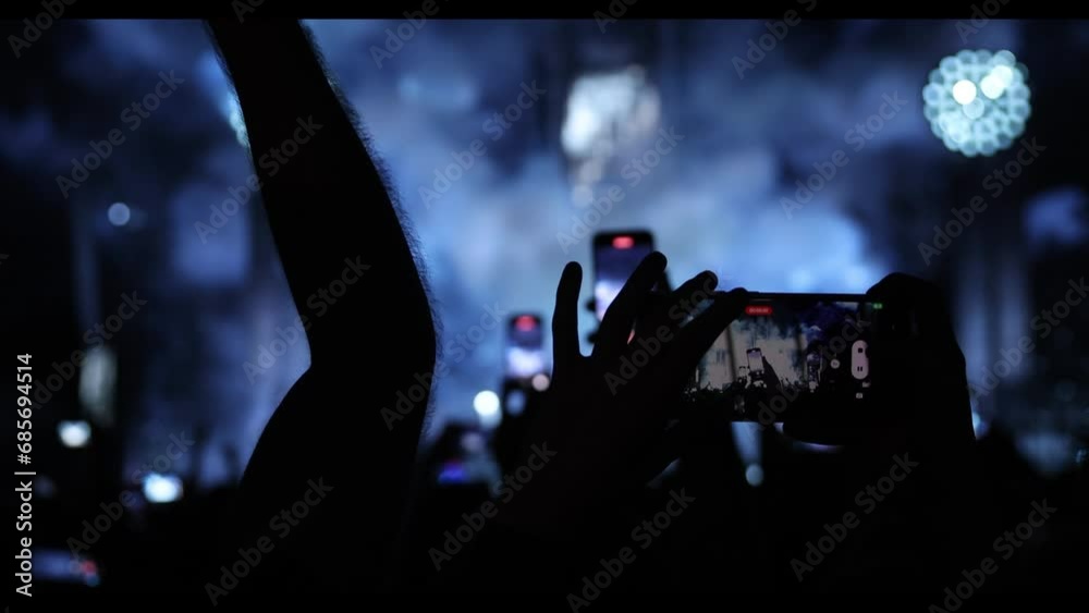 Silhouette of a hand with a mobile phone camera and enjoying the concert