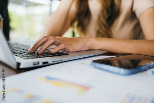 Happy Asian young businesswoman sitting alone at cafe desk with laptop computer she looking out of window, charming woman working outside and smiling in coffee shop freelancer thinking about new ideas