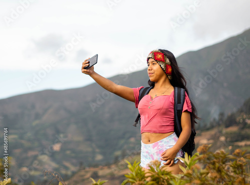 mujer excursionista video llamada con un smartphone en el acantilado de la montaña junto al fondo de nubes ,invierno,estilo de vida,turismo 