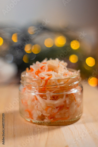 sauerkraut in a small jar against the background of a garland