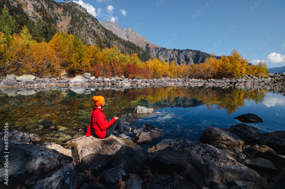 the girl is sitting on the shore of the Baduk lake