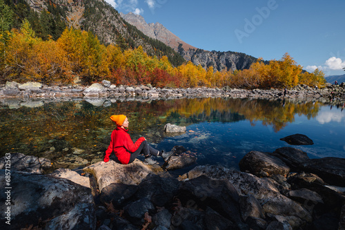 the girl is sitting on the shore of the Baduk lake