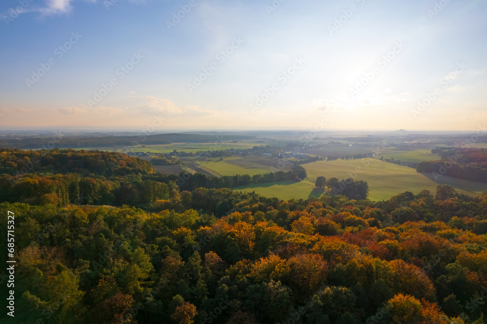 Serene autumnal panorama, european village, fields, and forest from a drone's eye view