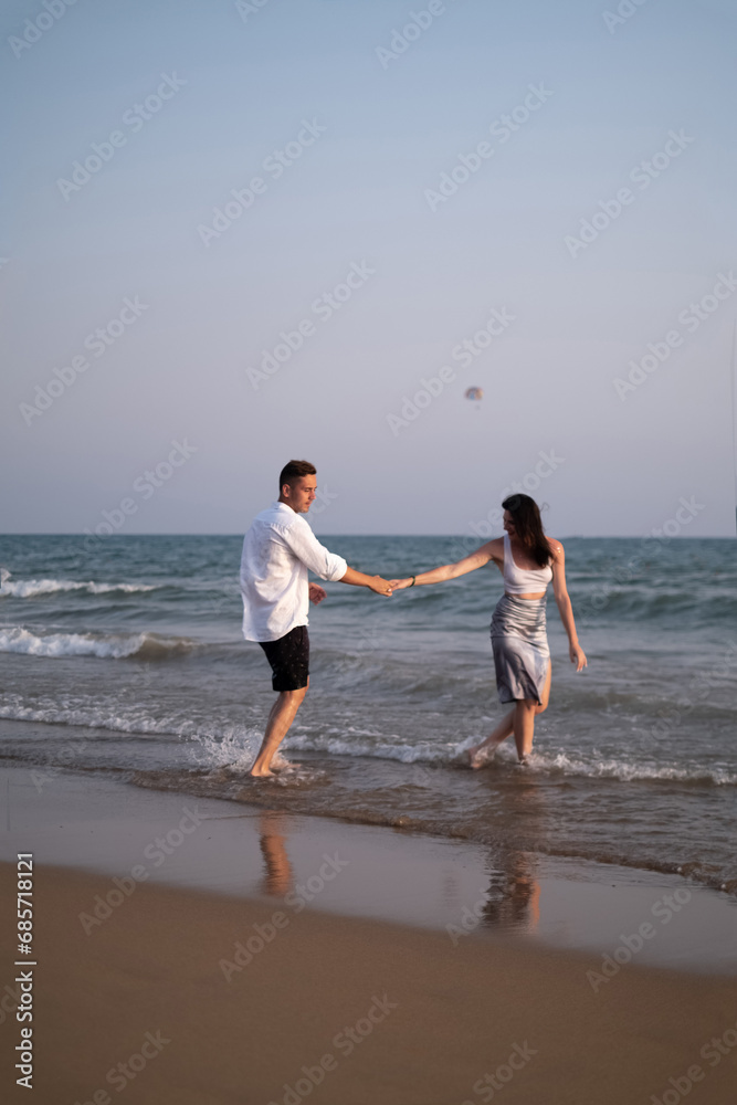 Young couple dancing together on sand at sunset, Sunset scene. Couple in love, happy couple. Valentine's Day, sstkLOVE Young couple dancing together on sand at sunset, Sunset scene. Couple in love, happy couple. Valentine's Day, sstkLOVE