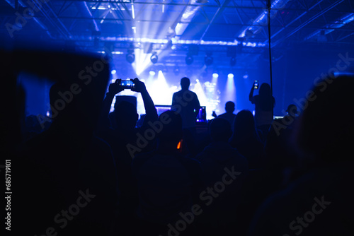 Many hands with smartphone on to record or take photos during live concert, rock concert, music festival, New Year celebration, nightclub party.