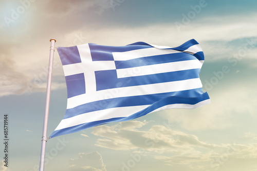 Greece national flag waving in beautiful sky. The symbol of the state on wavy silk fabric.