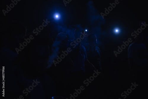 Rock concert, silhouettes of happy people raising their hands, rock concert, music festival, New Year celebration, nightclub party, dance floor, disco club