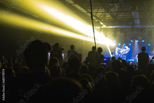 rock concert, music festival, New Year celebration, nightclub party, dance floor, disco club, many people standing with their hands up and clapping, happiness and nightlife concept