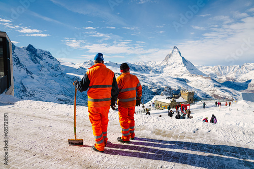 Workers enjoying the view of the mighty Matterhorn from Gornergrat on a sunny winter morning. 
