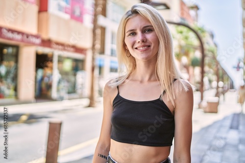 Young blonde woman smiling confident standing at street