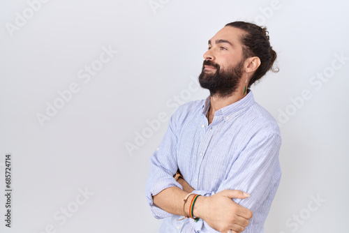 Hispanic man with beard wearing casual shirt looking to the side with arms crossed convinced and confident