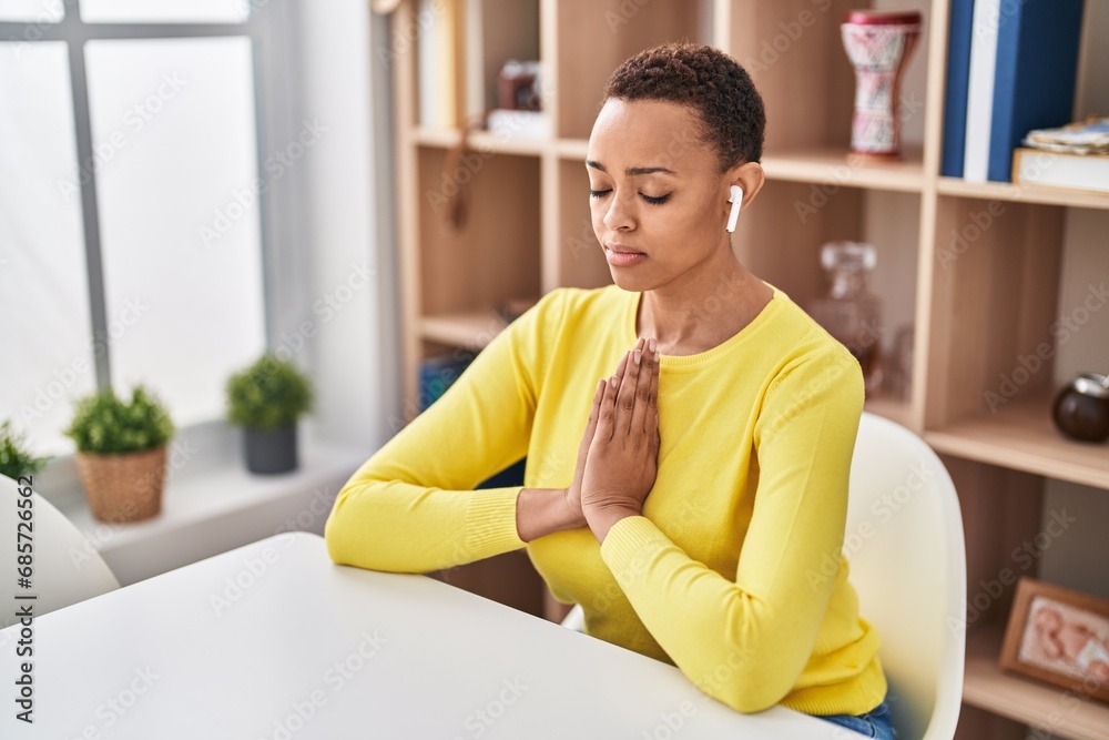 African american woman doing yoga exercise sitting on table at home African american woman doing yoga exercise sitting on table at home