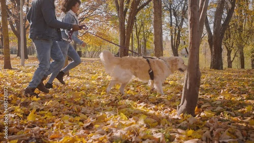 Wallpaper Mural Young African-American couple follows running dog in autumn park Torontodigital.ca