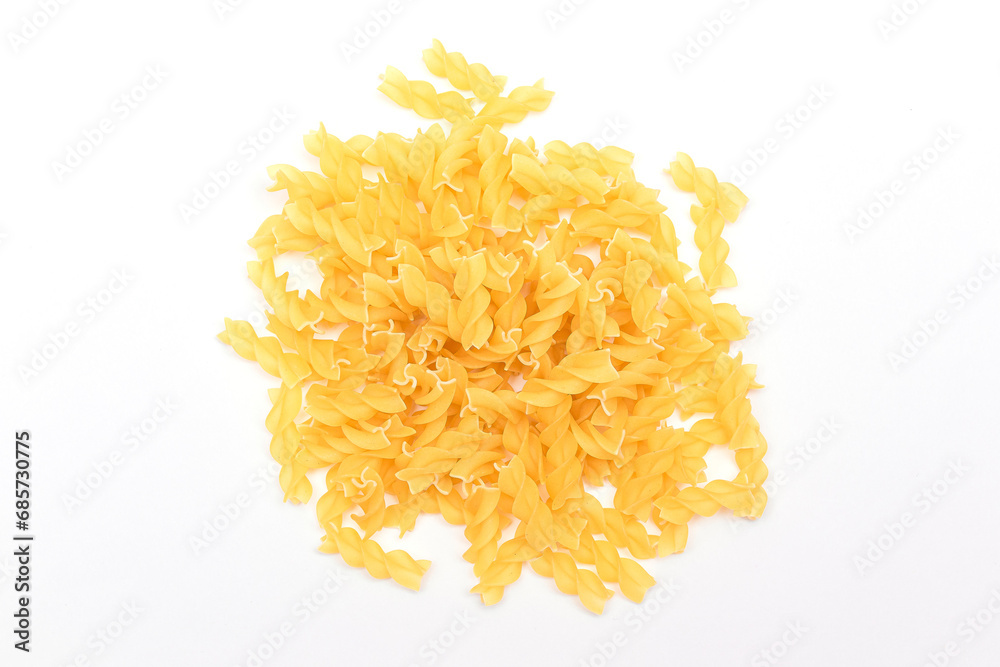 A Heap of Uncooked Fusilli Pasta Scattered on White Table. Raw and Dry Macaroni. Unhealthy and Fat Food. Italian Culture A Heap of Uncooked Fusilli Pasta Scattered on White Table. Raw and Dry Macaroni. Unhealthy and Fat Food. Italian Culture