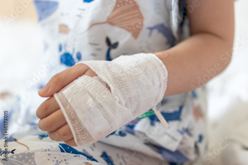 Close up child hand with saline IV solution in hospital photo