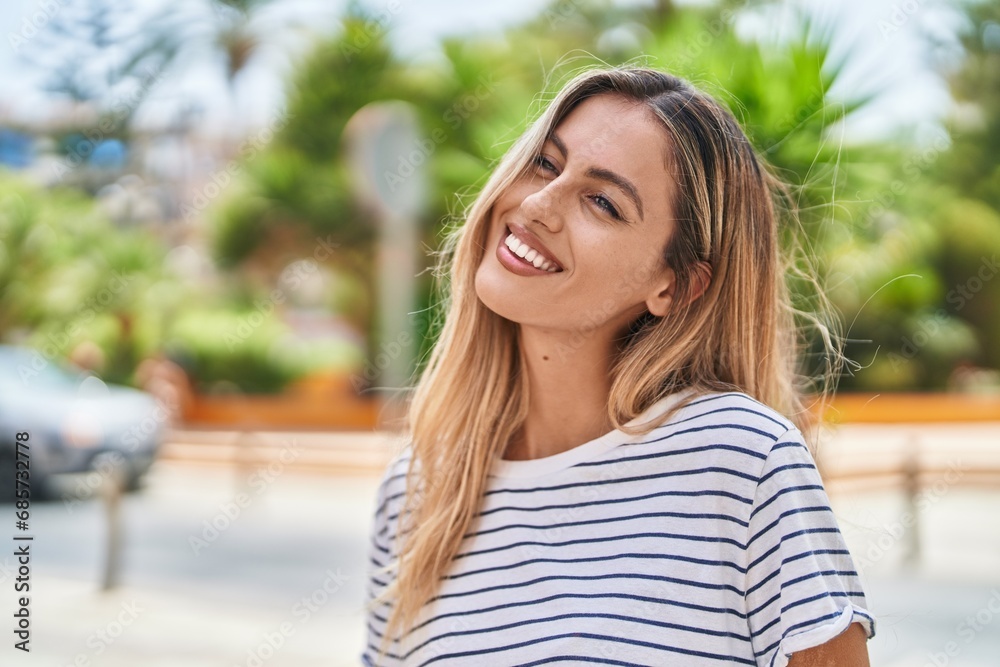 Young blonde woman smiling confident looking to the side at street Young blonde woman smiling confident looking to the side at street