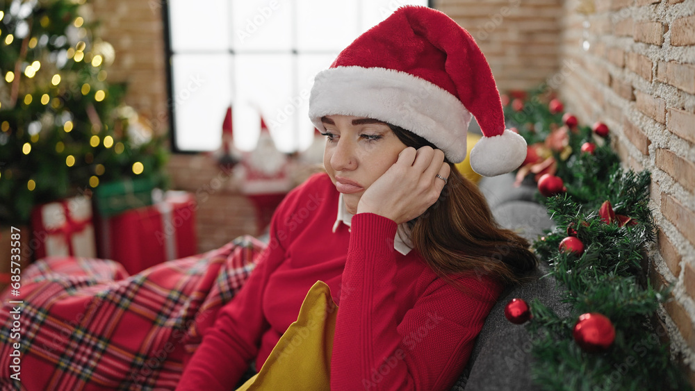 Young hispanic woman celebrating christmas with sad expression at home