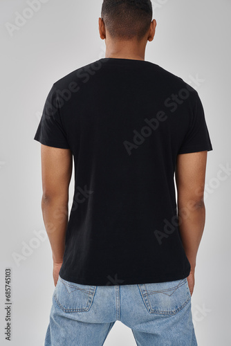 stylish african american male model posing in black t-shirt and jeans, copy space for advertising