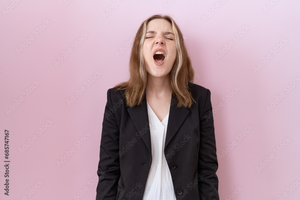 Young caucasian business woman wearing black jacket angry and mad screaming frustrated and furious, shouting with anger. rage and aggressive concept.