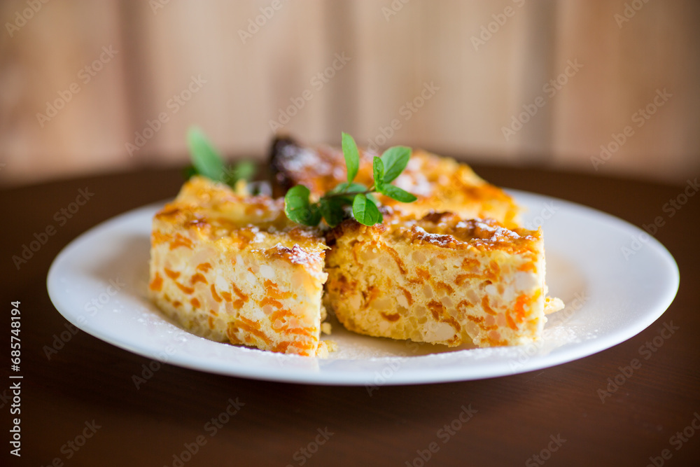 Cooked cottage cheese casserole with pieces of pumpkin inside.