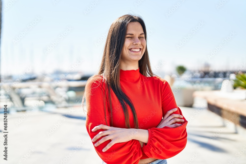Young beautiful hispanic woman standing with arms crossed gesture at seaside Young beautiful hispanic woman standing with arms crossed gesture at seaside