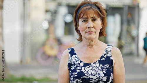 Middle age woman standing with serious expression at street