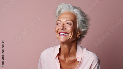 Portrait of Beautiful elder woman's smile with healthy white, straight teeth close-up on pink background with space for text