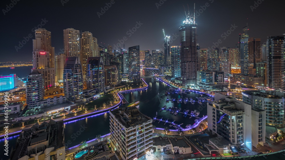 Obraz premium Panorama showing Dubai Marina skyscrapers and JBR district with luxury buildings and resorts aerial night timelapse