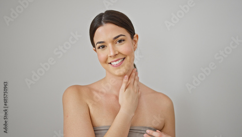 Young beautiful hispanic woman smiling confident massaging skin neck over isolated white background