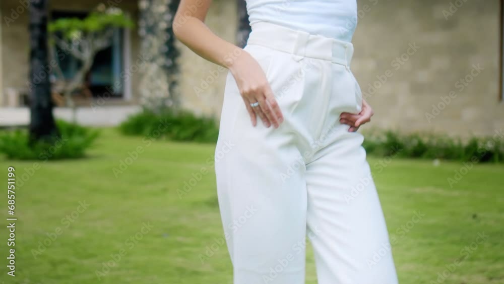 Young girl in white clothes walks outside in backyard of house Young girl in white clothes walks outside in backyard of house