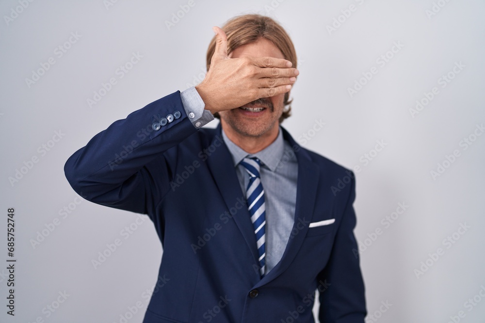Caucasian man with mustache wearing business clothes smiling and laughing with hand on face covering eyes for surprise. blind concept. Caucasian man with mustache wearing business clothes smiling and laughing with hand on face covering eyes for surprise. blind concept.