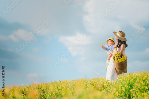 Obraz na płótnie Mother with little child in flower blooming garden. woman with son in green leaves,happy family outdoors in spring w salonie