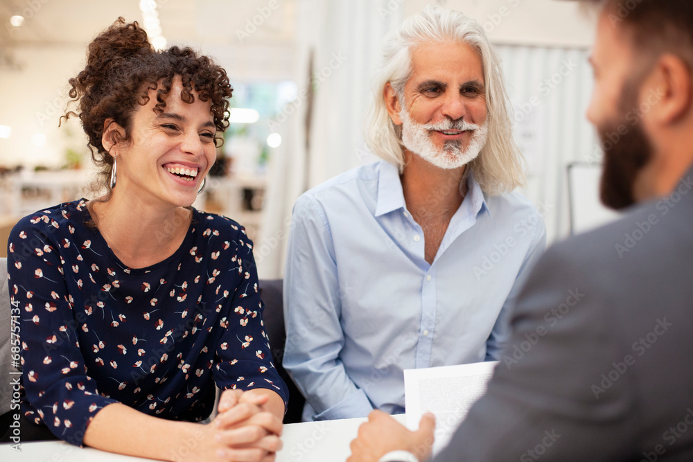 Adult couple smiling while having a meeting with lawyer Adult couple smiling while having a meeting with lawyer