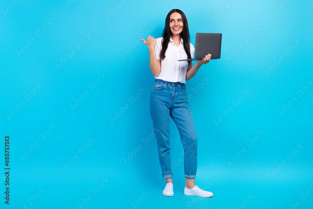 Full length photo of clever dreamy girl dressed white shirt texting modern gadget thumb empty space isolated blue color background Full length photo of clever dreamy girl dressed white shirt texting modern gadget thumb empty space isolated blue color background