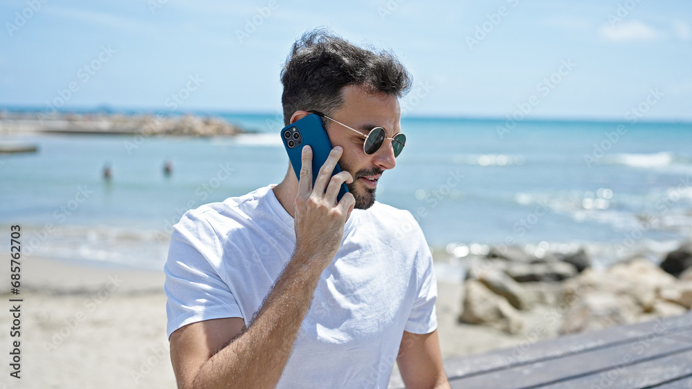 Young hispanic man smiling confident talking on the smartphone at seaside Young hispanic man smiling confident talking on the smartphone at seaside