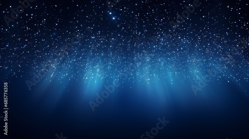 Dark blue background is illuminated by the glow of particles