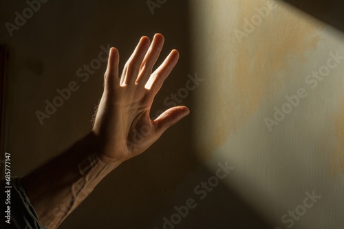 Man's hand on the background of a wall with light and shadow