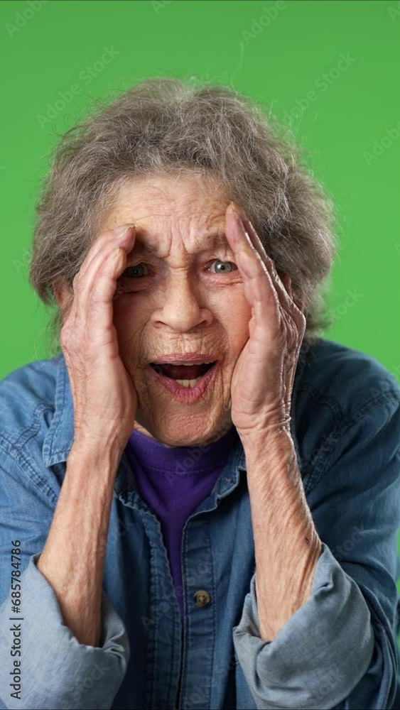 Vertical video portrait of excited successful elderly senior old woman with wrinkled skin and grey hair isolated on green screen background studio Vertical video portrait of excited successful elderly senior old woman with wrinkled skin and grey hair isolated on green screen background studio